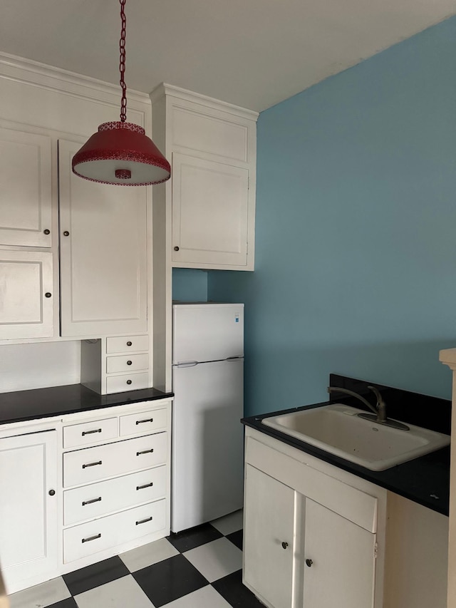 2615 Park Ave Unit 310, Minneapolis, MN 55407 - kitchen with freestanding refrigerator, a sink, tile patterned floors, and white cabinets