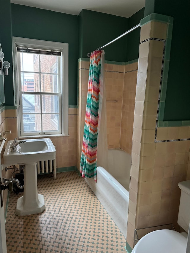 2615 Park Ave Unit 310, Minneapolis, MN 55407 - bathroom featuring tile walls, shower / bath combo, toilet, and a wainscoted wall