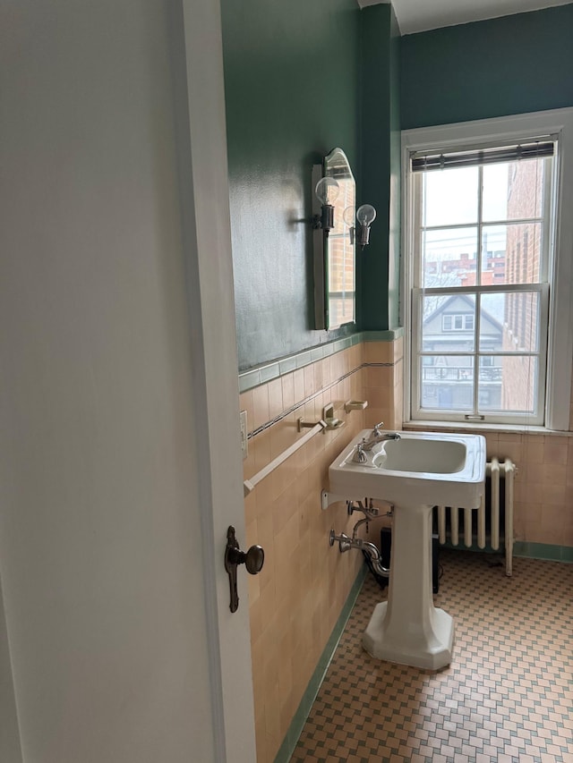 2615 Park Ave Unit 310, Minneapolis, MN 55407 - bathroom with tile walls, a wainscoted wall, tile patterned floors, and radiator heating unit