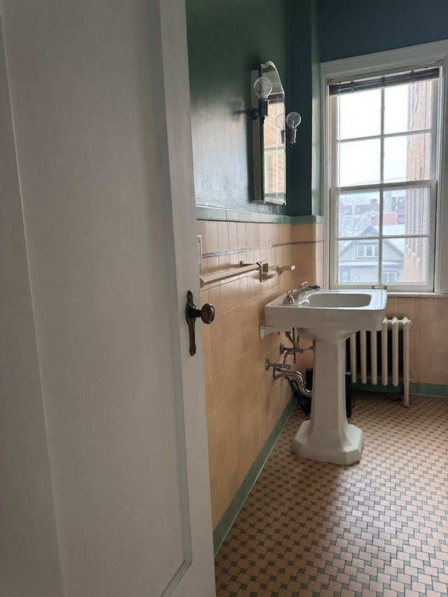 2615 Park Ave Unit 310, Minneapolis, MN 55407 - bathroom with radiator, tile walls, and wainscoting