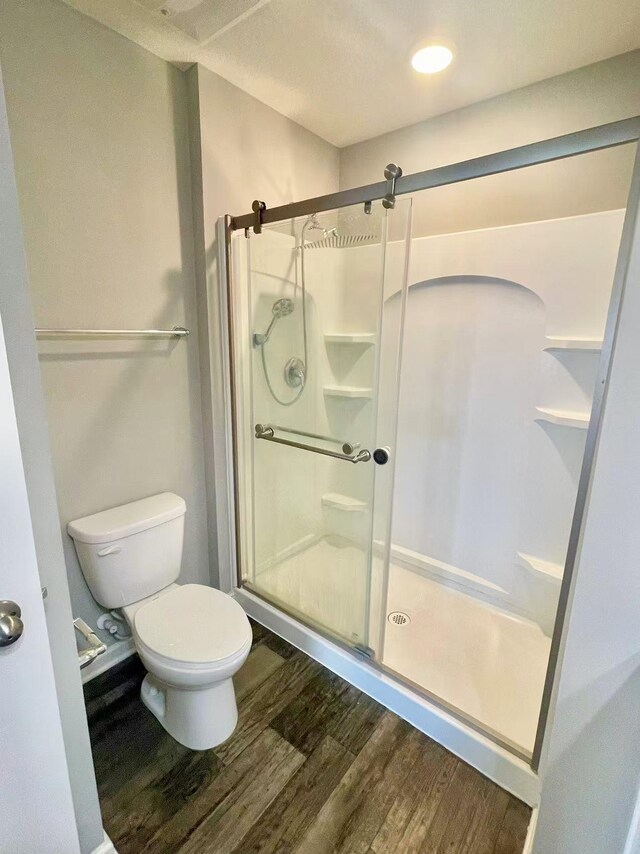 8521 Titanium Cir, Woodbury, MN 55129 - full bath featuring wood finished floors, a stall shower, and toilet