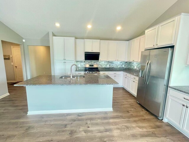 8521 Titanium Cir, Woodbury, MN 55129 - kitchen featuring stainless steel appliances, a sink, vaulted ceiling, backsplash, and light stone counters