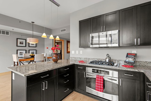 215 10th Ave S Unit 730, Minneapolis, MN 55415 - kitchen featuring stainless steel appliances, light wood-style floors, a peninsula, and dark cabinets