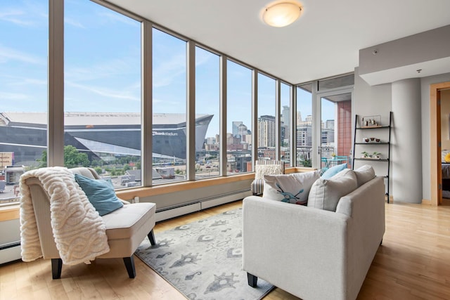 215 10th Ave S Unit 730, Minneapolis, MN 55415 - living area featuring plenty of natural light, a view of skyline, a baseboard heating unit, wood finished floors, and expansive windows