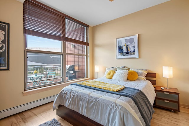215 10th Ave S Unit 730, Minneapolis, MN 55415 - bedroom featuring wood finished floors and a baseboard heating unit