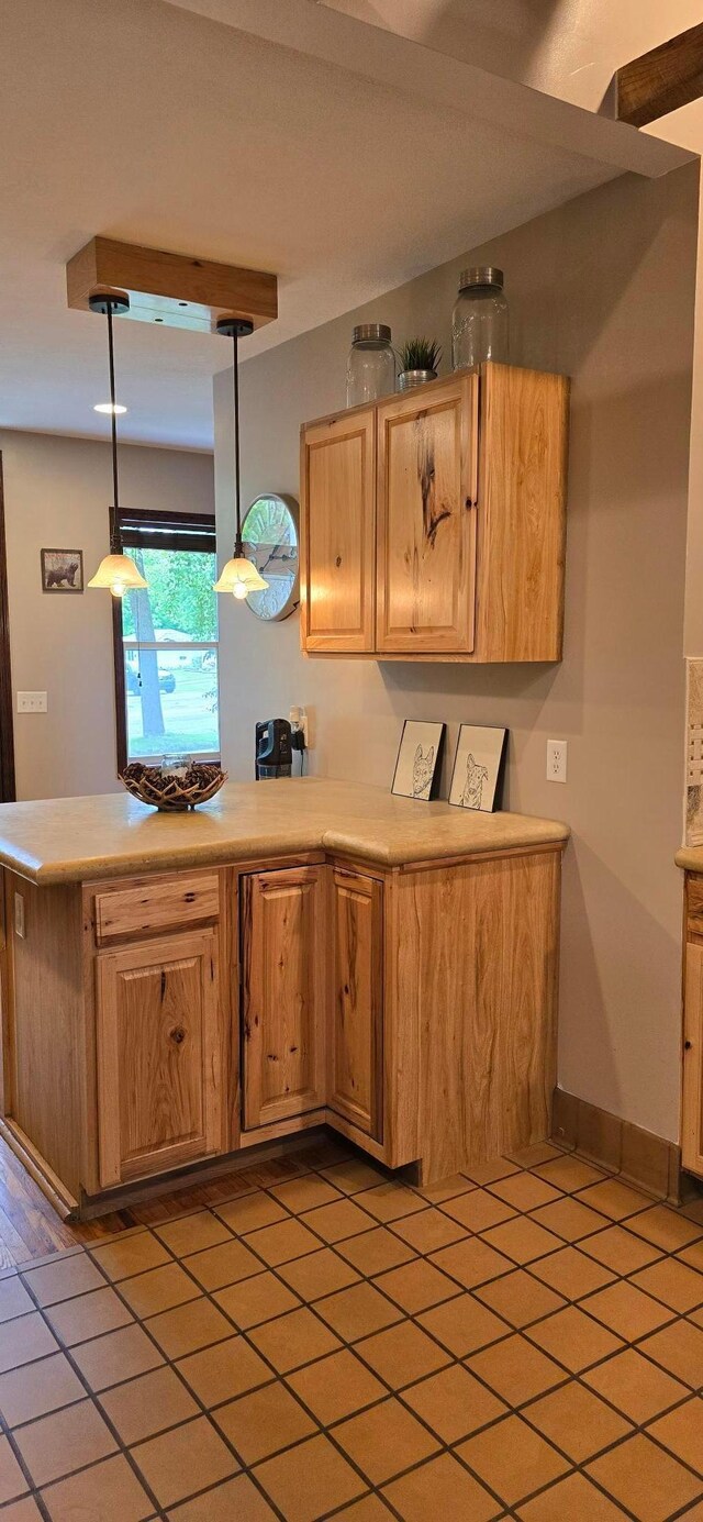 526 Mound St, Owatonna, MN 55060 - kitchen featuring light countertops, light tile patterned flooring, a peninsula, and pendant lighting