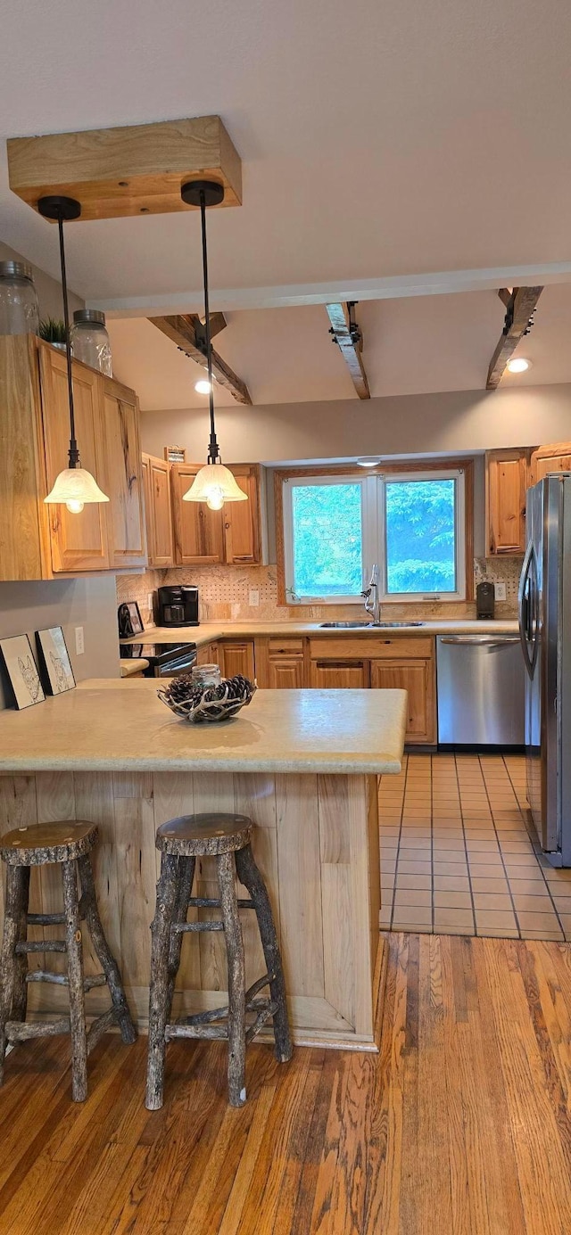 526 Mound St, Owatonna, MN 55060 - kitchen with stainless steel appliances, tasteful backsplash, a peninsula, light countertops, and a breakfast bar area