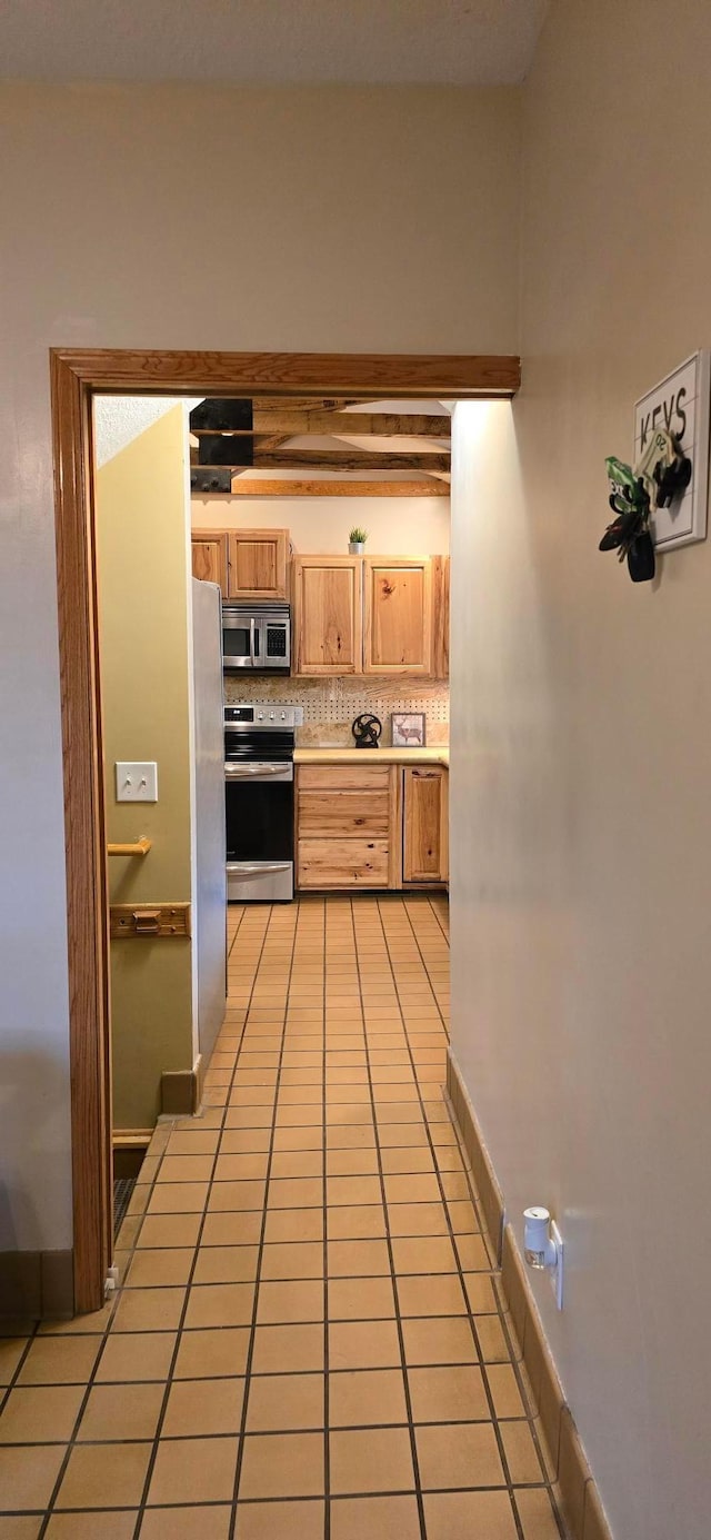 526 Mound St, Owatonna, MN 55060 - kitchen with appliances with stainless steel finishes, light countertops, light tile patterned floors, decorative backsplash, and light brown cabinetry