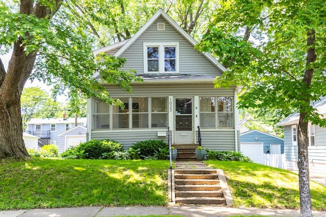 1023 Avon St N, Saint Paul, MN 55103 - bungalow-style home with a garage, a front lawn, an outdoor structure, and entry steps