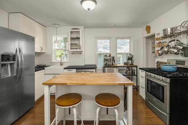 1023 Avon St N, Saint Paul, MN 55103 - kitchen featuring appliances with stainless steel finishes, butcher block countertops, a breakfast bar area, and dark wood finished floors