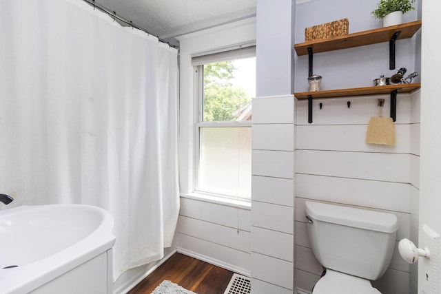 1023 Avon St N, Saint Paul, MN 55103 - full bathroom with wood finished floors and a shower with shower curtain