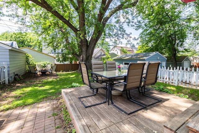 1023 Avon St N, Saint Paul, MN 55103 - wooden deck with outdoor dining area, a fenced backyard, and a storage unit