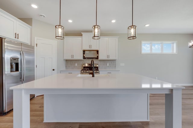 15354 112th Ave N, Dayton, MN 55369 - kitchen with appliances with stainless steel finishes, a sink, light countertops, a center island with sink, and tasteful backsplash