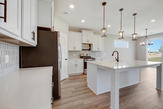 15354 112th Ave N, Dayton, MN 55369 - kitchen with stainless steel appliances, light wood-style flooring, decorative backsplash, a sink, and light countertops