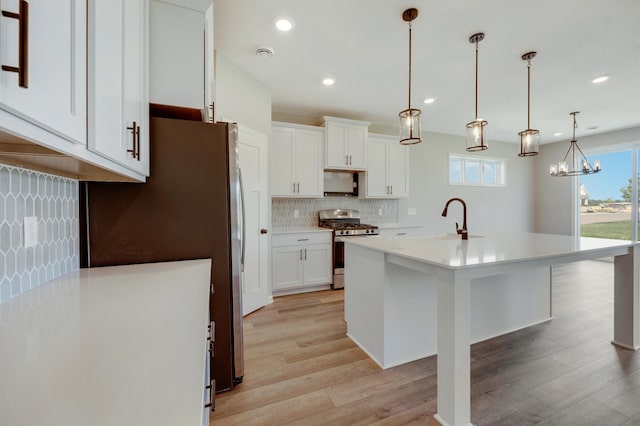 15354 112th Ave N, Dayton, MN 55369 - kitchen featuring appliances with stainless steel finishes, a sink, tasteful backsplash, light wood-style floors, and light countertops