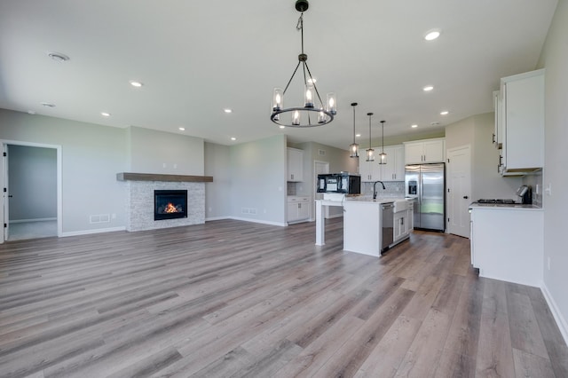 15354 112th Ave N, Dayton, MN 55369 - kitchen with stainless steel appliances, open floor plan, an island with sink, a chandelier, and baseboards