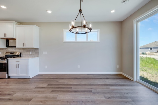 15354 112th Ave N, Dayton, MN 55369 - kitchen with stainless steel gas range oven, a chandelier, white cabinets, light wood-style flooring, and backsplash