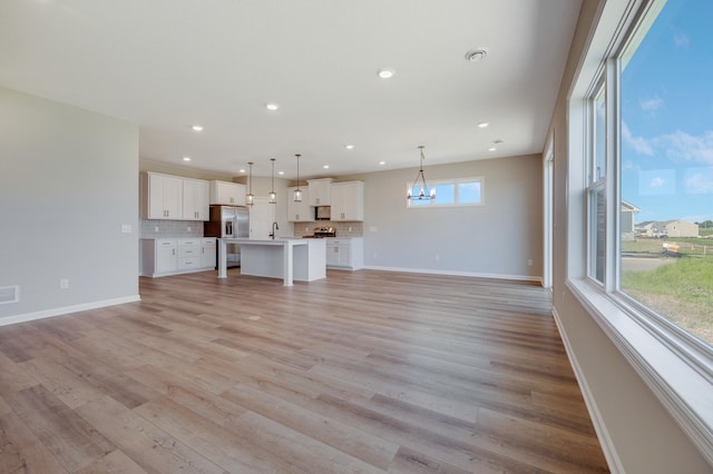 15354 112th Ave N, Dayton, MN 55369 - unfurnished living room with baseboards, a sink, a chandelier, light wood-style floors, and recessed lighting