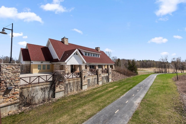 15354 112th Ave N, Dayton, MN 55369 - view of front facade featuring stone siding, a chimney, and board and batten siding