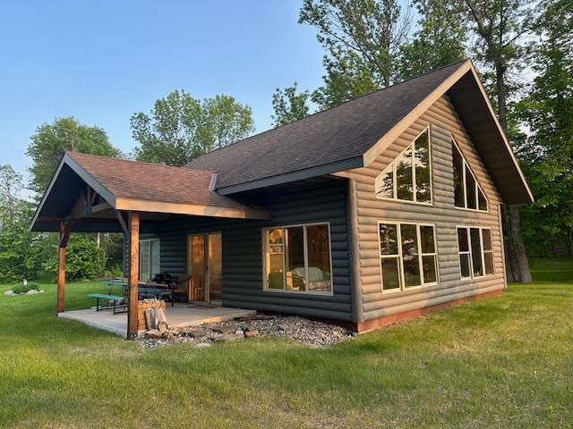 19373 Ethel Beach Rd NE, Kelliher, MN 56650 - back of property featuring a patio area, a lawn, and roof with shingles