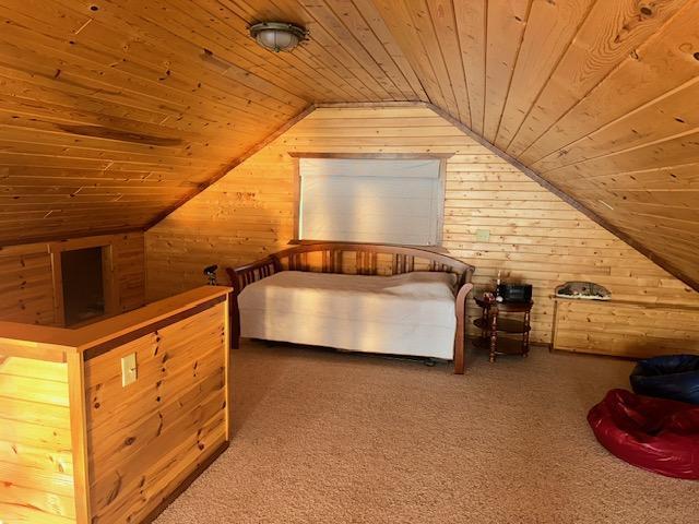19373 Ethel Beach Rd NE, Kelliher, MN 56650 - unfurnished bedroom featuring wood ceiling, wooden walls, lofted ceiling, and carpet floors
