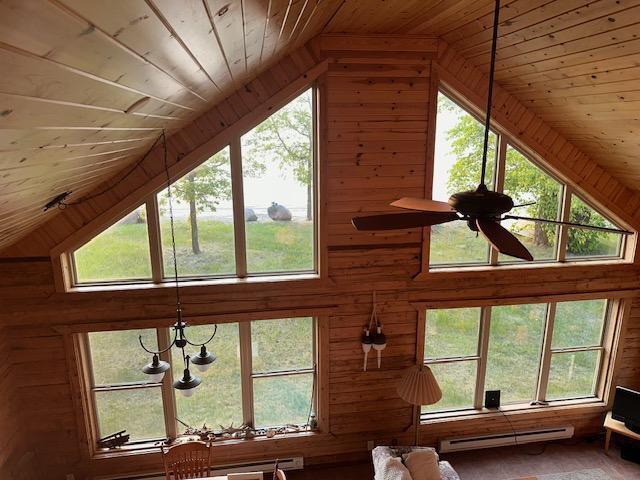 19373 Ethel Beach Rd NE, Kelliher, MN 56650 - detailed view of wooden ceiling, a baseboard heating unit, wood walls, and ceiling fan