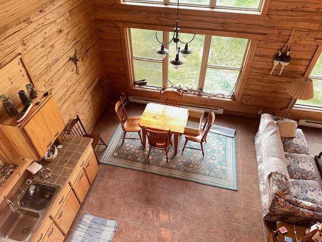19373 Ethel Beach Rd NE, Kelliher, MN 56650 - tiled dining room featuring plenty of natural light and wooden walls