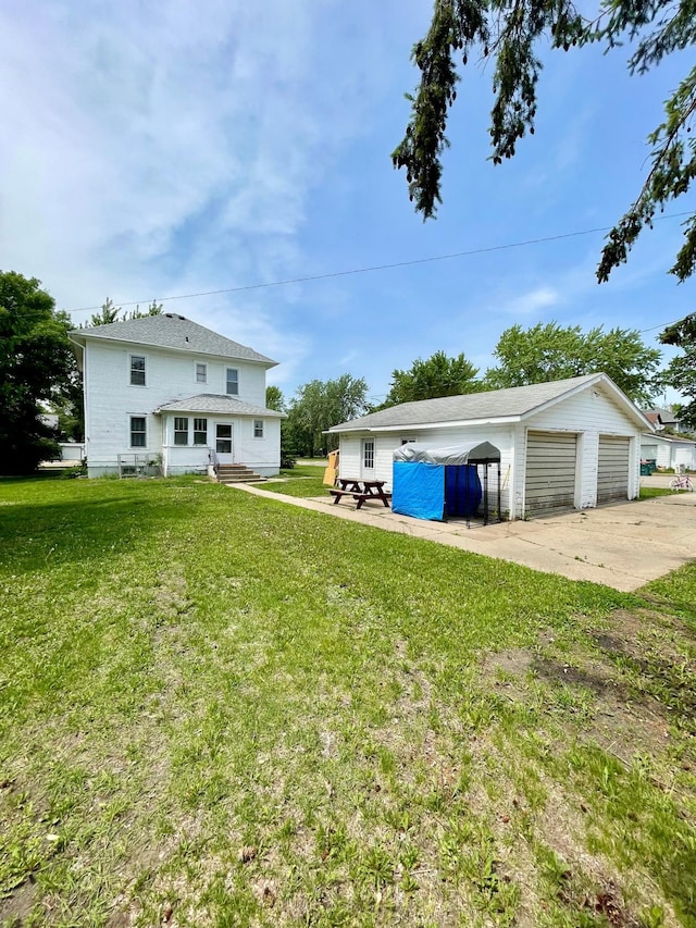 506 3rd St SW, Wadena, MN 56482 - view of green lawn featuring an outbuilding, a detached garage, and entry steps