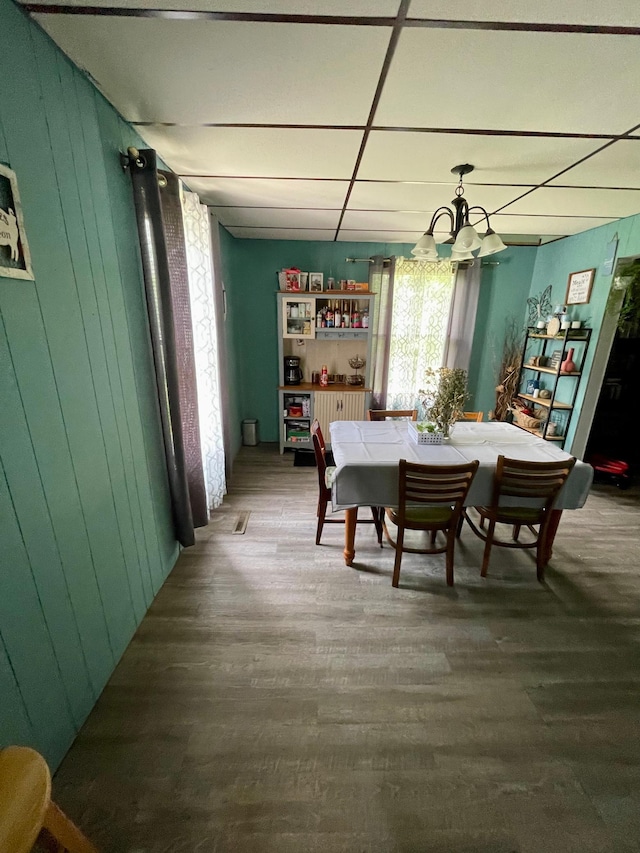506 3rd St SW, Wadena, MN 56482 - dining room featuring a chandelier, wood finished floors, and wood walls