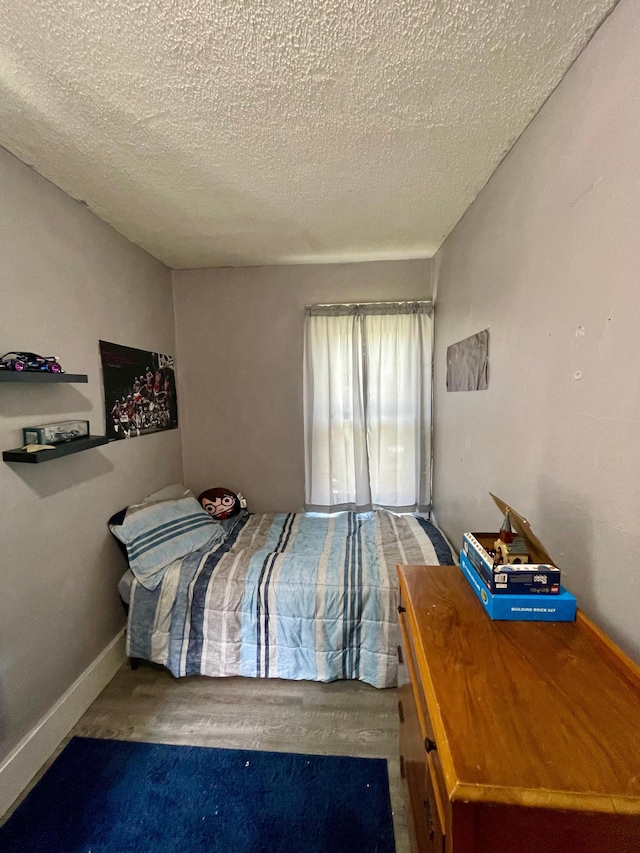 506 3rd St SW, Wadena, MN 56482 - bedroom with a textured ceiling, wood finished floors, and baseboards