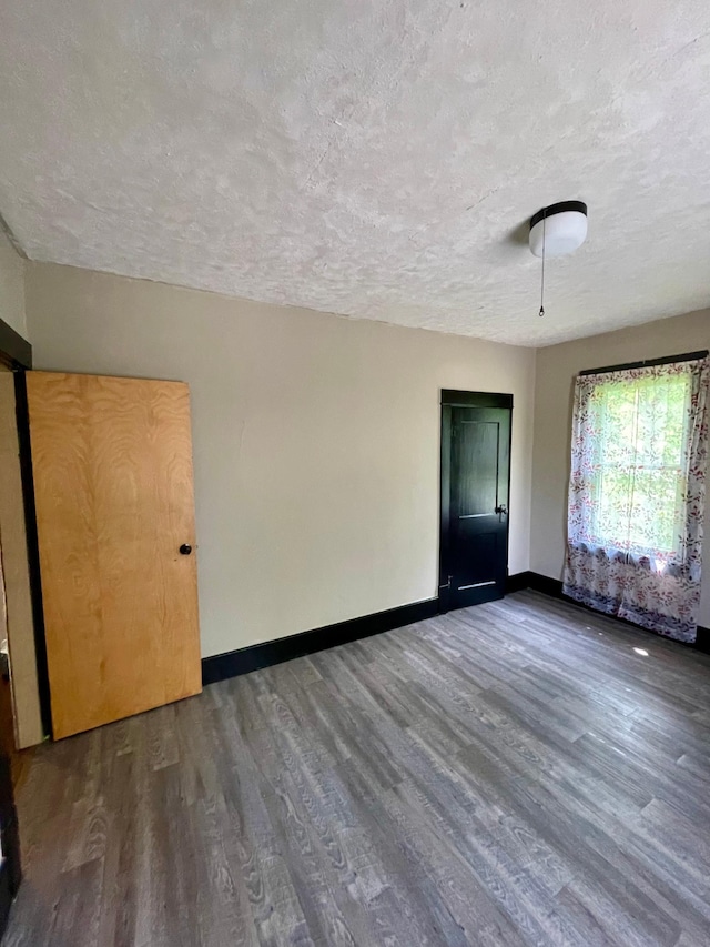 506 3rd St SW, Wadena, MN 56482 - empty room featuring a textured ceiling, wood finished floors, and baseboards