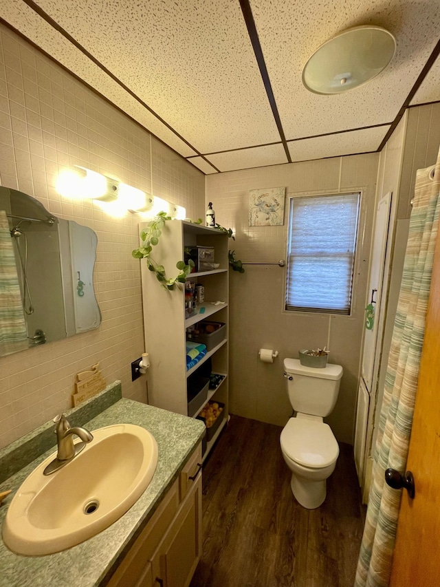 506 3rd St SW, Wadena, MN 56482 - full bath featuring wood finished floors, vanity, toilet, curtained shower, and tile walls