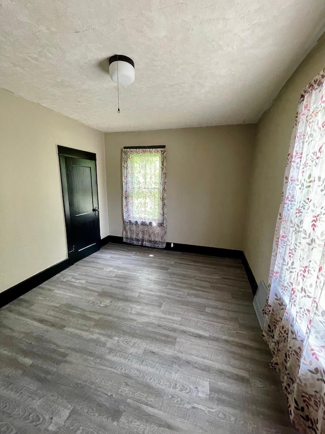 506 3rd St SW, Wadena, MN 56482 - unfurnished room featuring baseboards, wood finished floors, and a textured ceiling
