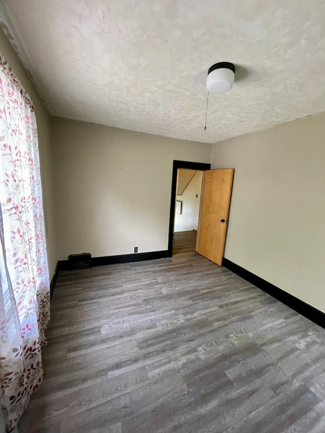 506 3rd St SW, Wadena, MN 56482 - unfurnished room featuring baseboards, wood finished floors, and a textured ceiling