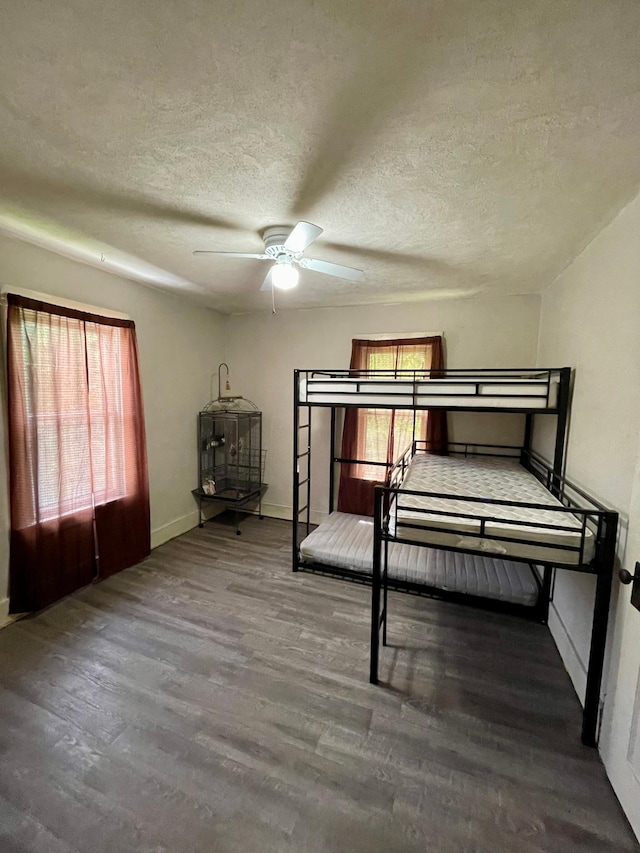 506 3rd St SW, Wadena, MN 56482 - bedroom with wood finished floors, a textured ceiling, multiple windows, and baseboards