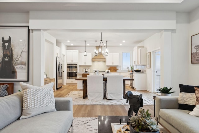 6640 Wolfberry Curv, Minnetrista, MN 55331 - living room with light wood-style floors, a chandelier, and recessed lighting