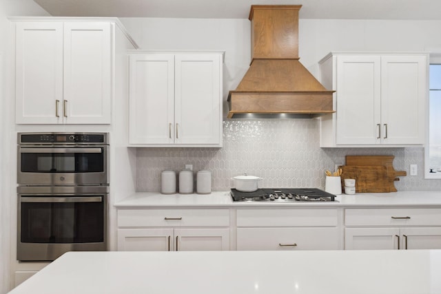6640 Wolfberry Curv, Minnetrista, MN 55331 - kitchen featuring appliances with stainless steel finishes, custom range hood, decorative backsplash, and white cabinets