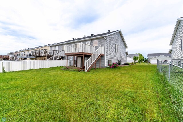 1131 38 1/2 Ave W, West Fargo, ND 58078 - back of property featuring stairs, a fenced backyard, and a wooden deck