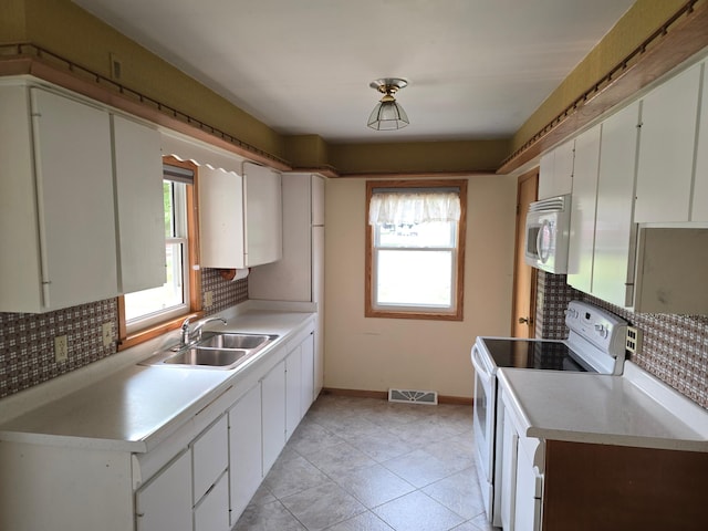 415 9th St N, Cannon Falls, MN 55009 - kitchen with white appliances, a sink, tasteful backsplash, and white cabinetry