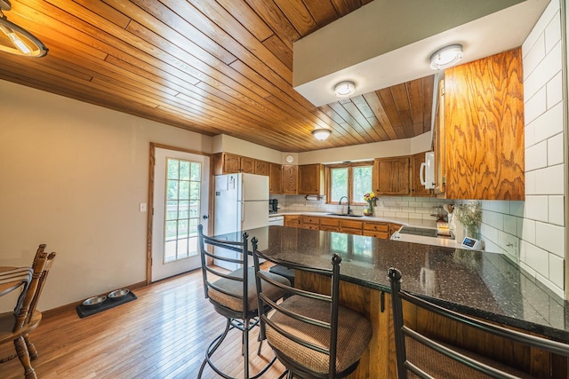 42174 Bur Oak Hills Loop, Pelican Twp, MN 56572 - kitchen featuring wooden ceiling, white appliances, brown cabinetry, a peninsula, and backsplash