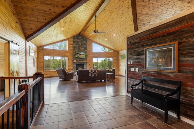32305 Little E Lake Rd, Bigfork, MN 56628 - living area with wood walls, plenty of natural light, high vaulted ceiling, a fireplace, and wooden ceiling with exposed beams