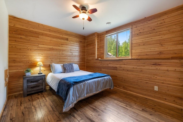 32305 Little E Lake Rd, Bigfork, MN 56628 - bedroom featuring wooden walls, hardwood / wood-style flooring, and a ceiling fan