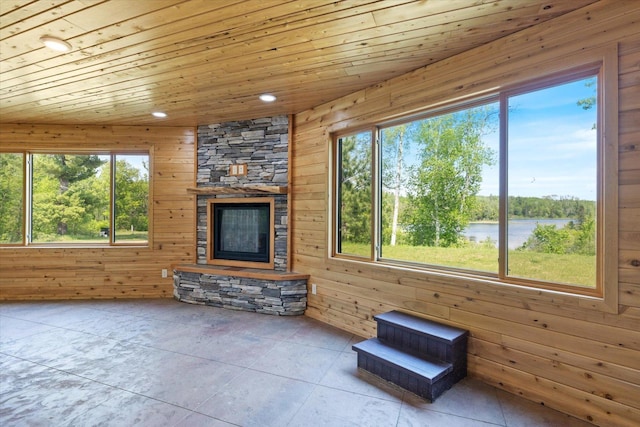 32305 Little E Lake Rd, Bigfork, MN 56628 - unfurnished living room featuring wood walls, wood ceiling, a fireplace, recessed lighting, and a water view