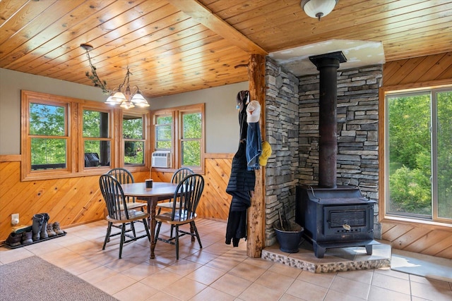 32305 Little E Lake Rd, Bigfork, MN 56628 - tiled dining room with a wood stove, wooden ceiling, wood walls, wainscoting, and cooling unit