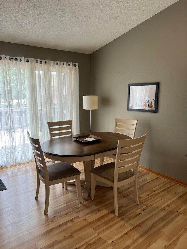 728 7th St, Litchfield, MN 55355 - dining room with light wood finished floors, a textured ceiling, and baseboards