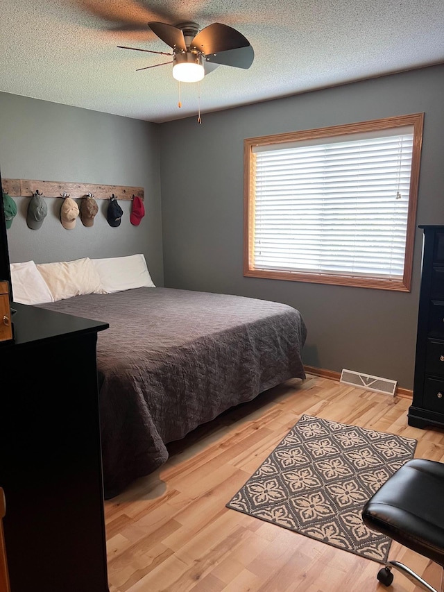 728 7th St, Litchfield, MN 55355 - bedroom featuring light wood-style flooring, ceiling fan, and a textured ceiling