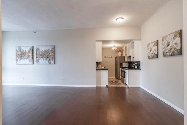 433 7th St Unit 2317, Minneapolis, MN 55415 - unfurnished living room with dark wood-style flooring, baseboards, and a textured ceiling