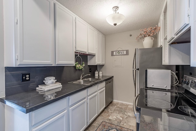 433 7th St Unit 2317, Minneapolis, MN 55415 - kitchen featuring a sink, appliances with stainless steel finishes, baseboards, a textured ceiling, and white cabinets