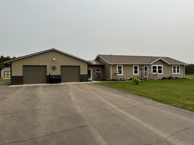 21250 Farm View Dr, Park Rapids, MN 56470 - ranch-style home with a front yard, a garage, board and batten siding, and an outbuilding