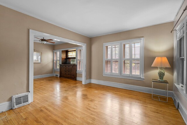 3553 Dupont Ave S, Minneapolis, MN 55408 - unfurnished living room with light wood-style flooring, baseboards, a ceiling fan, and cooling unit